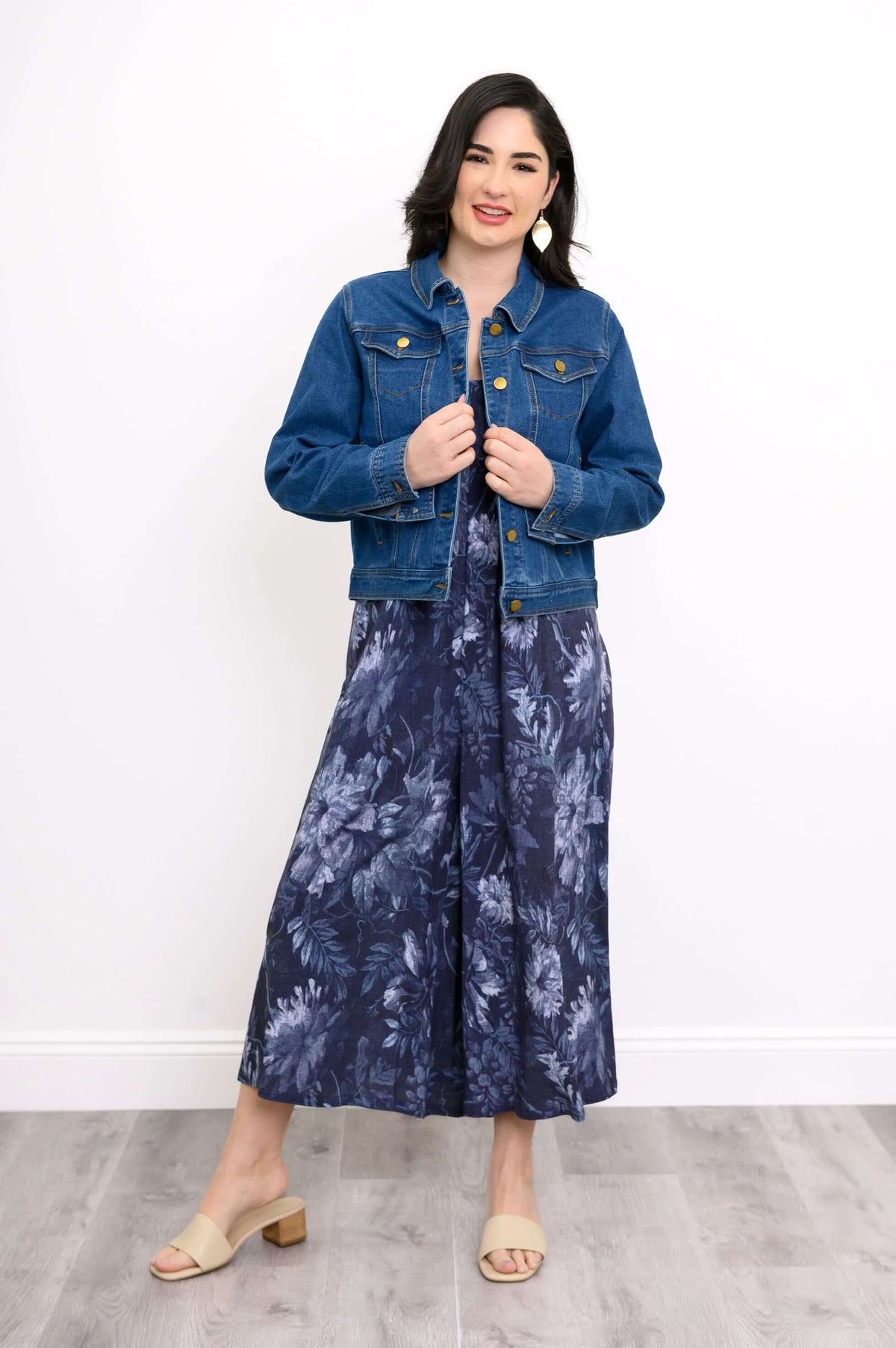 Woman in a blue floral jumpsuit styled with a classic blue denim jacket