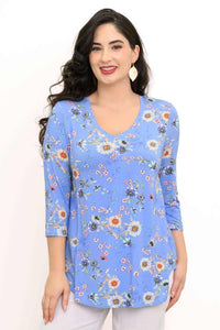 Woman wearing a blue V-neck floral top with three-quarter sleeves, closeup view