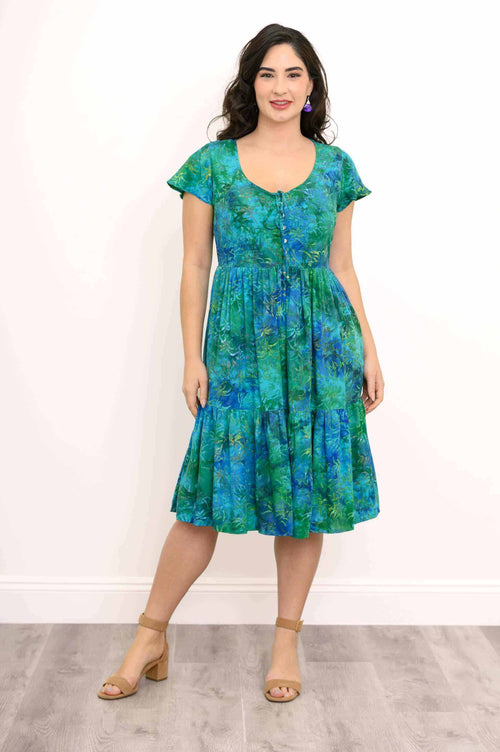 Woman wearing a blue and green floral flutter sleeve dress with front buttons