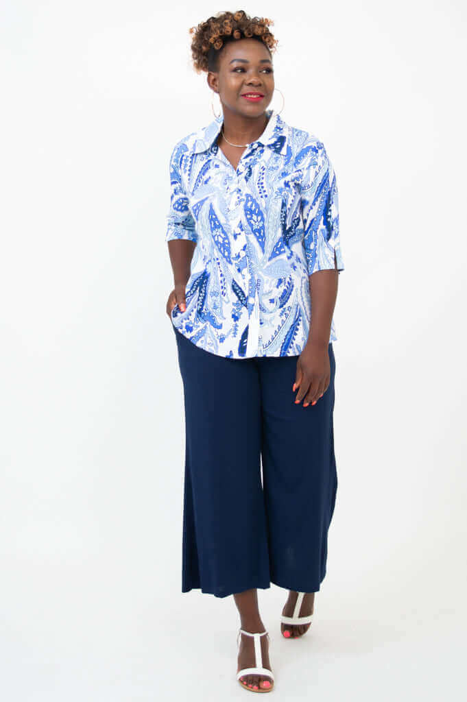 Woman in a blue and white blouse paired with navy wide-leg pants, front angled view