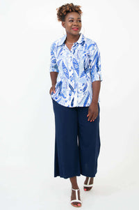 Woman in a blue and white blouse paired with navy wide-leg pants, front angled view