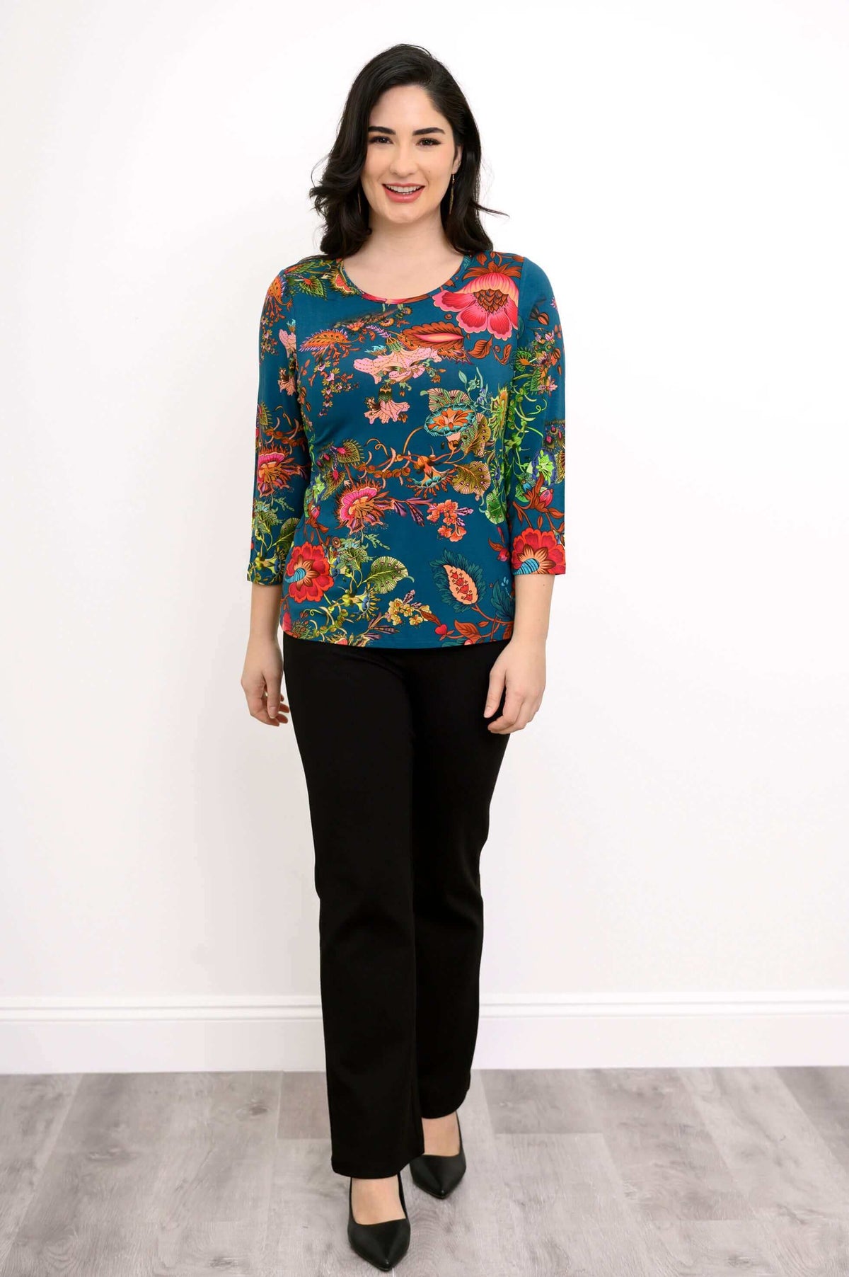 Woman modeling blue bamboo tee with vibrant floral print, front full-length view