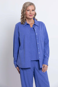 Woman in a blue button-front shirt and pants set, partial front view