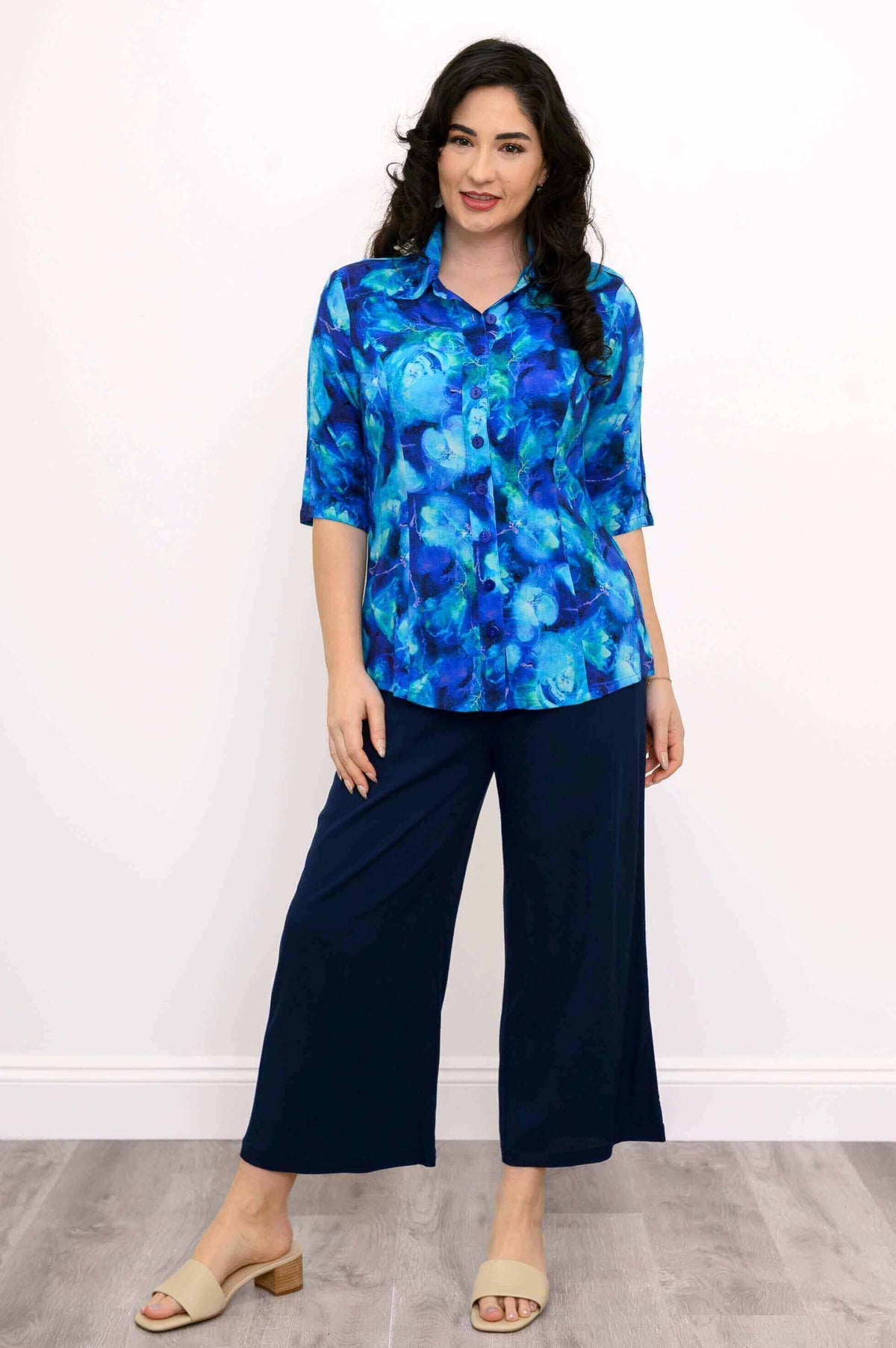 Model in a blue collared blouse and navy culottes with beige sandals