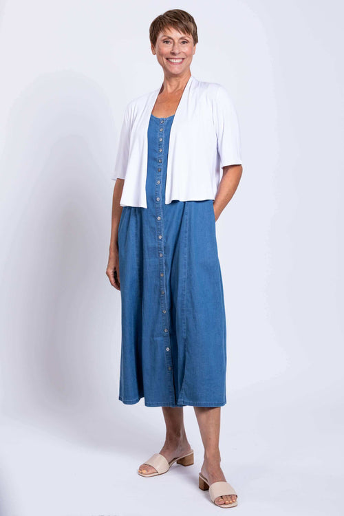 Woman modeling a blue denim maxi dress layered with a white short-sleeve cardigan