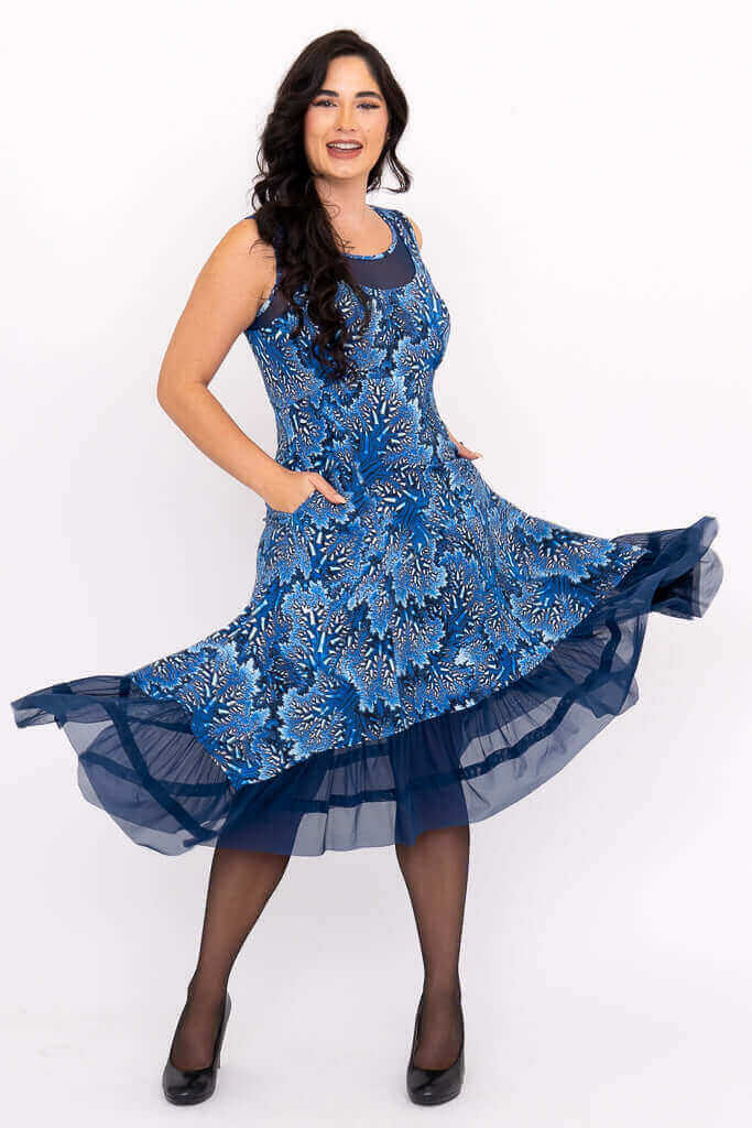 Model showing full A-line blue floral Danube dress with flared mesh hem