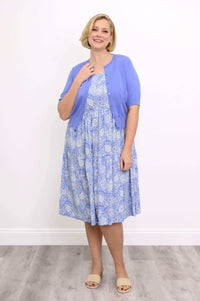 Woman wearing a blue floral Juni Dress with a lavender cardigan and sandals