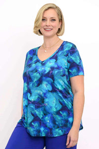 Woman wearing a blue floral bamboo V-neck top with short sleeves, smiling