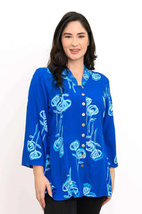 Woman wearing a blue blouse with light blue floral design and button front