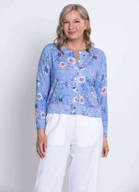 Three-quarter front view showing the blue floral cardigan and white pants