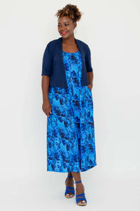 Blue floral jumpsuit styled with a navy cardigan, front view
