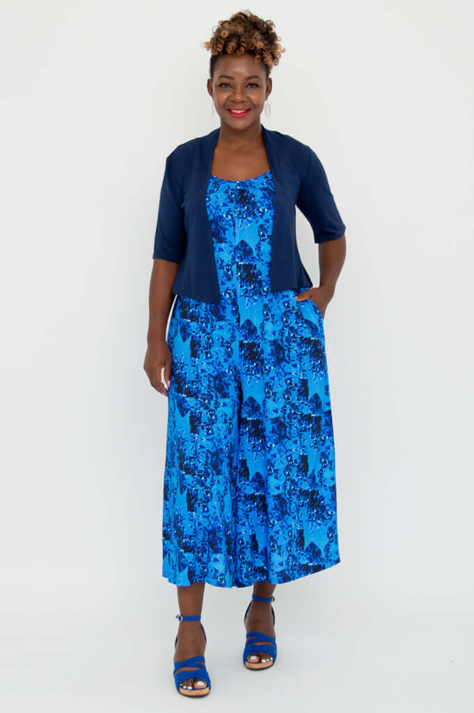 Full front view of blue floral jumpsuit with navy cardigan