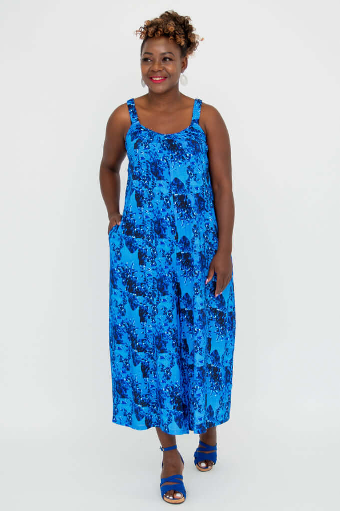 Woman walking in blue floral jumpsuit with side pockets