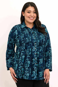 Woman wearing a blue floral long sleeve blouse with button front and smocked bodice, smiling