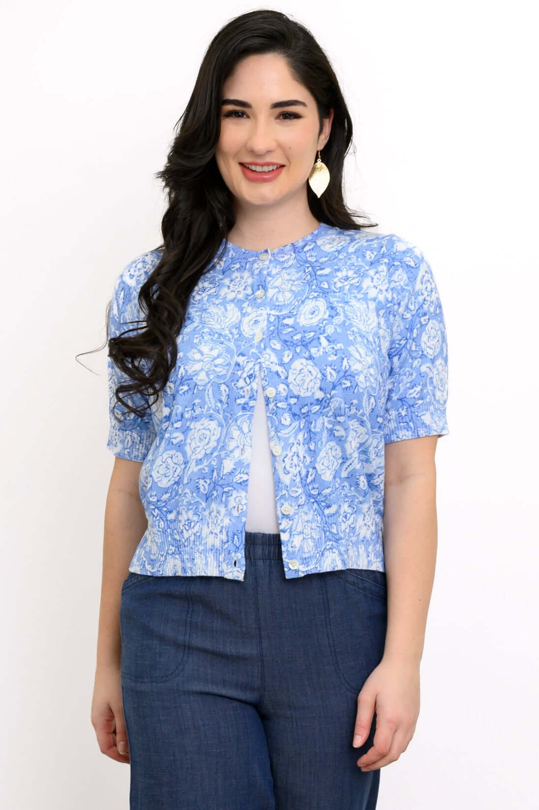 Woman wearing a blue floral short sleeve knit cardigan with curved hem