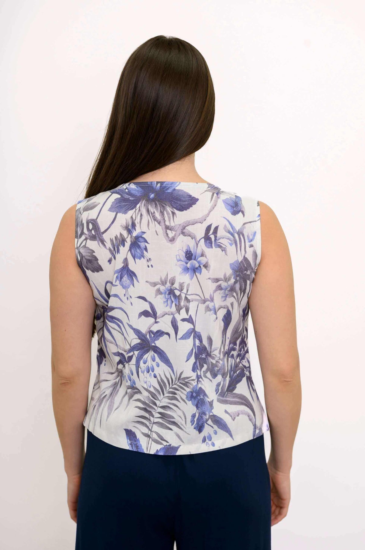 Back view of blue floral sleeveless cropped tank top on model