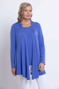 Woman wearing a long sleeve blue open front jacket with white pants, close-up view