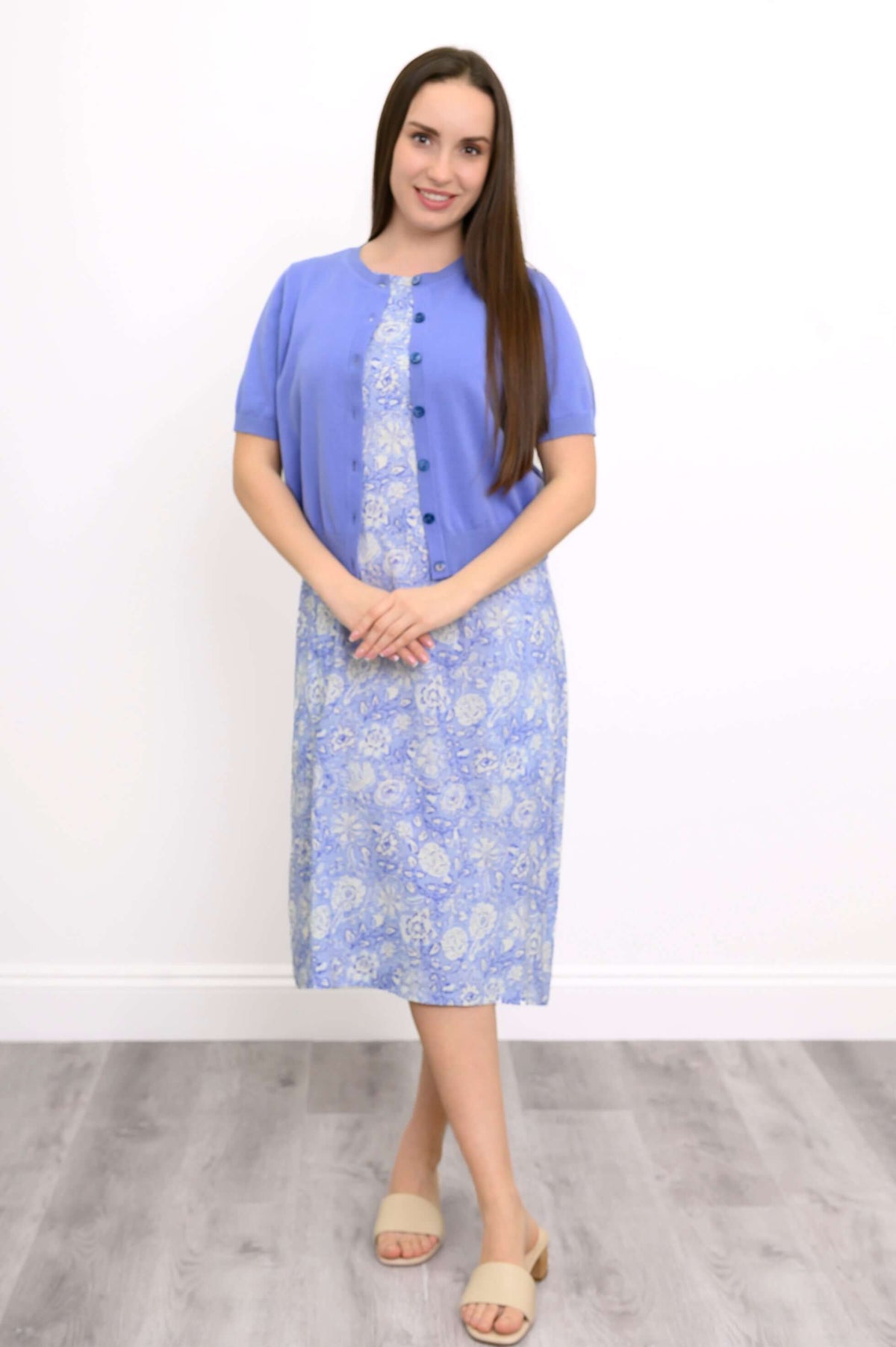 Woman wearing a blue paisley midi dress paired with a blue cardigan