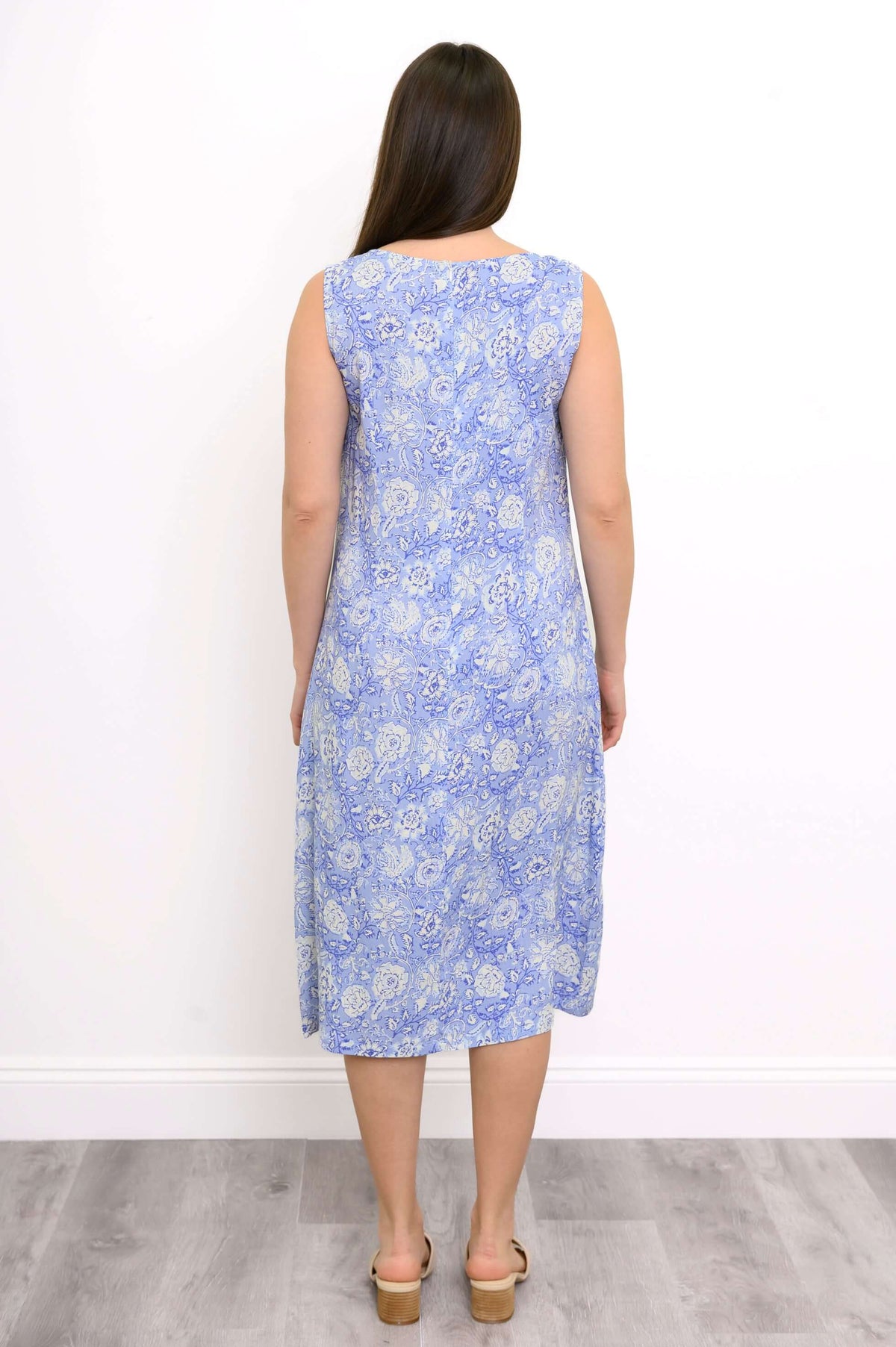 Back view of a woman in a blue paisley sleeveless midi dress