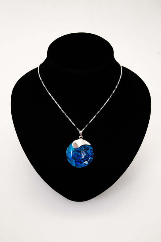 Sterling silver blue shell pendant necklace displayed on a black velvet bust