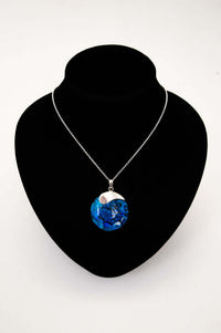 Sterling silver blue shell pendant necklace displayed on a black velvet bust