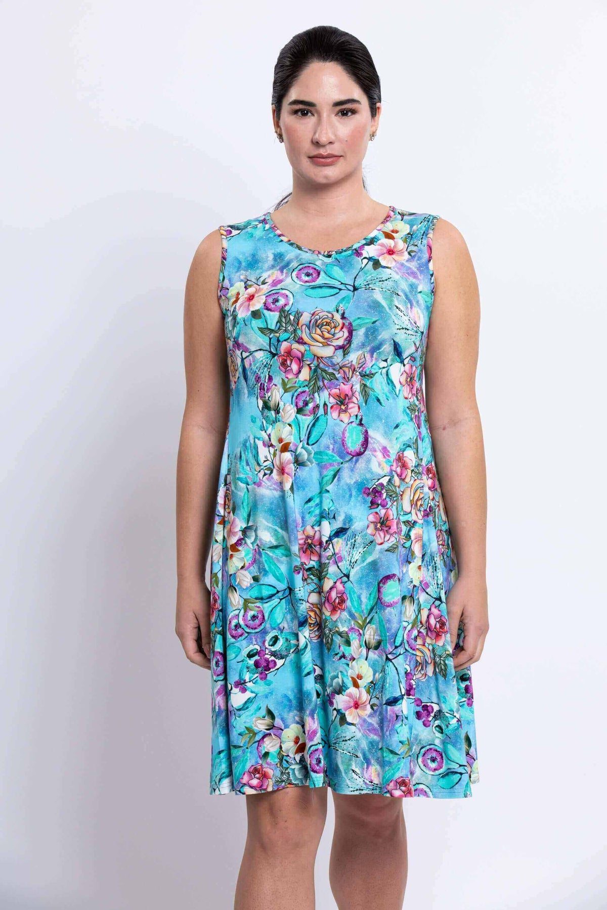 Close-up of woman in blue sleeveless floral dress, facing forward