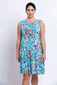 Close-up of woman in blue sleeveless floral dress, facing forward
