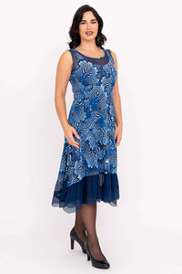Woman wearing a blue sleeveless mesh dress with floral patterns and layered hem