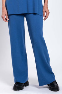 Close-up of blue straight-leg pants with smooth waistband and black shoes
