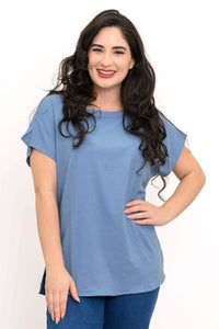 Woman wearing a blue relaxed-fit tee with dolman cap sleeves and rounded boatneck