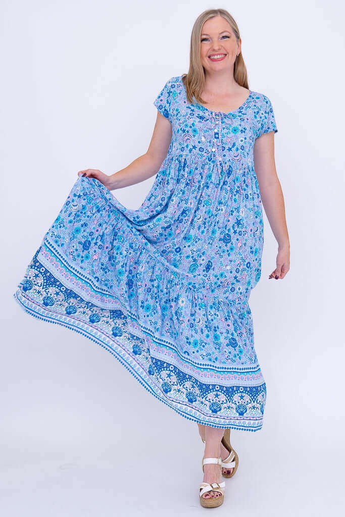 Woman holding out skirt of tiered blue floral maxi dress