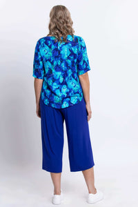 Back view of woman in blue watercolor blouse and blue pants
