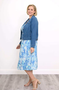 Woman in a blue watercolor tank dress paired with a blue denim jacket, side view