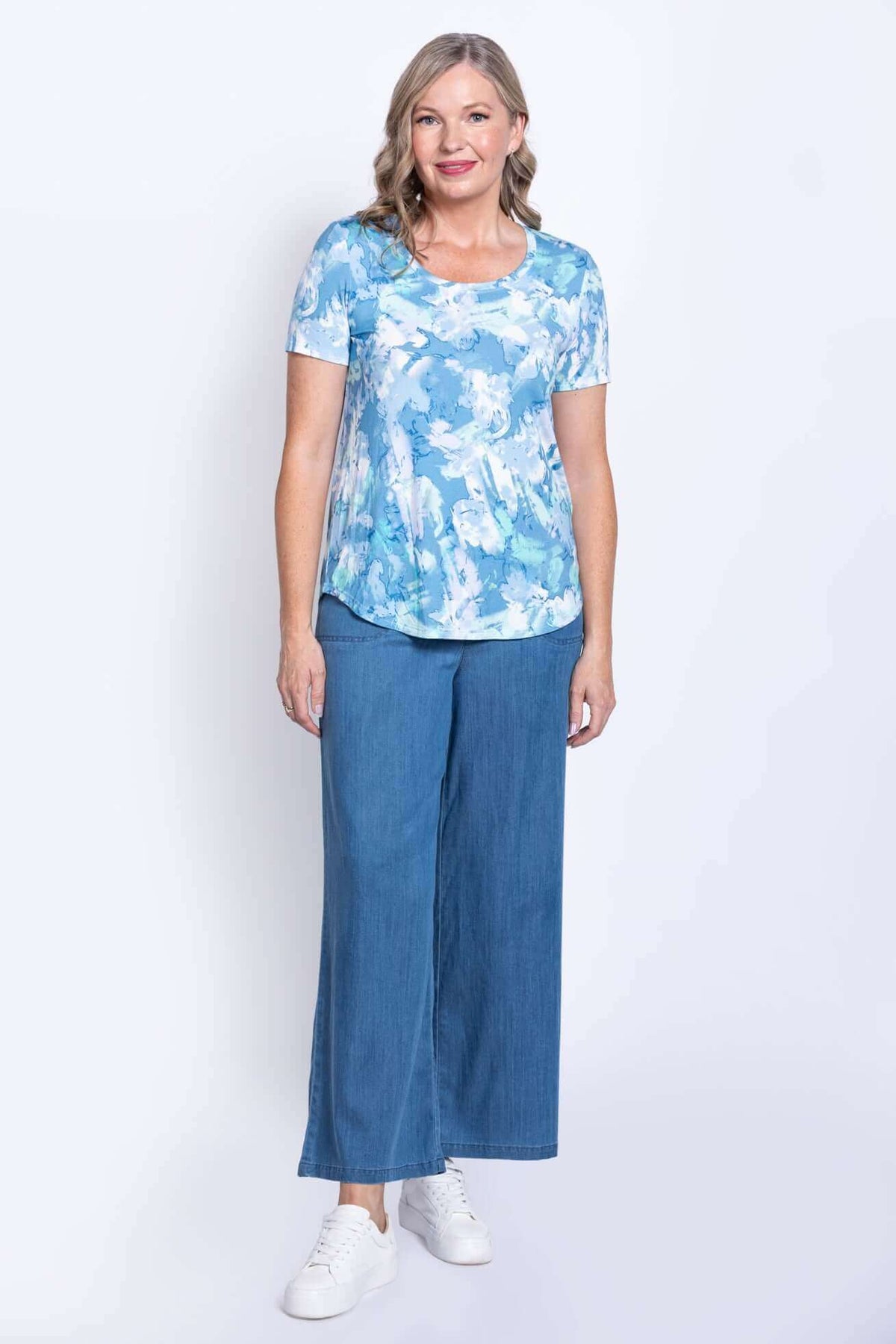 Woman in blue watercolor bamboo tee and wide-leg denim jeans standing facing forward
