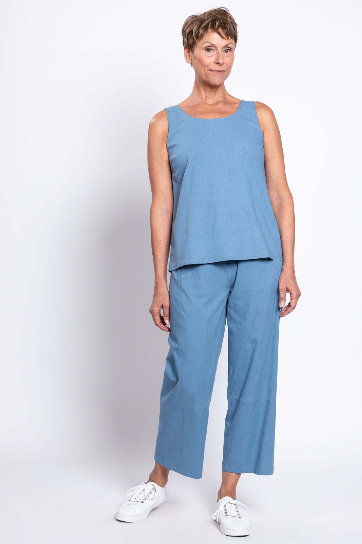 Light blue linen-blend sleeveless top and cropped pant set styled with white sneakers