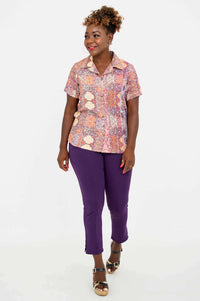 Woman walking in boho mosaic patterned shirt and purple pants