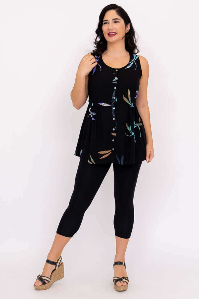 Woman posing in a black boho batik tank top and black leggings with wedge sandals