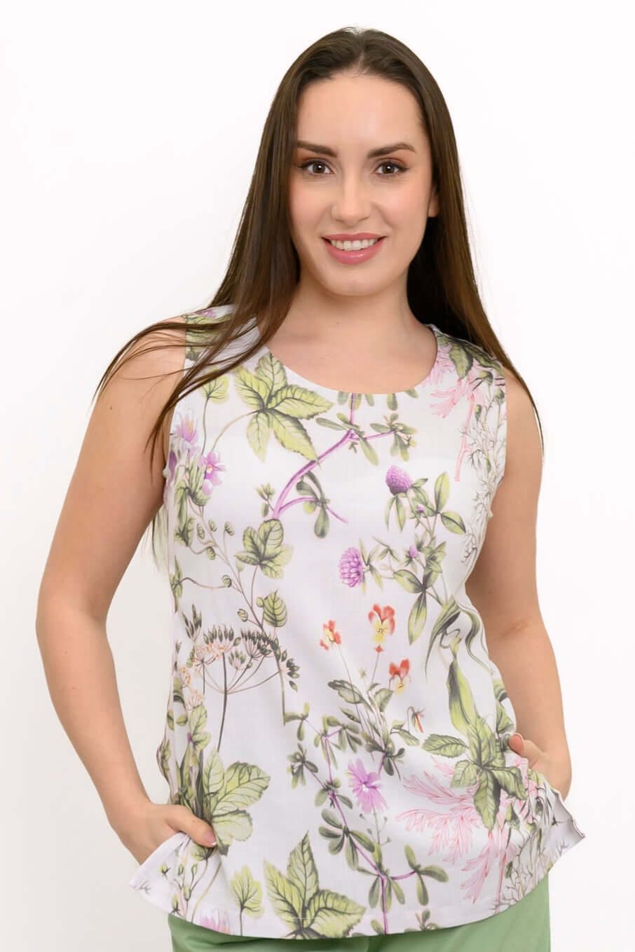 Woman wearing a sleeveless scoop neck tank top with a colorful botanical print
