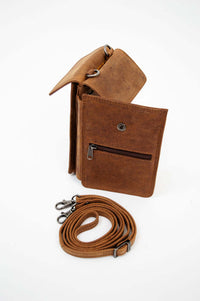 Standing brown leather wallet with back pocket and detachable strap lying beside