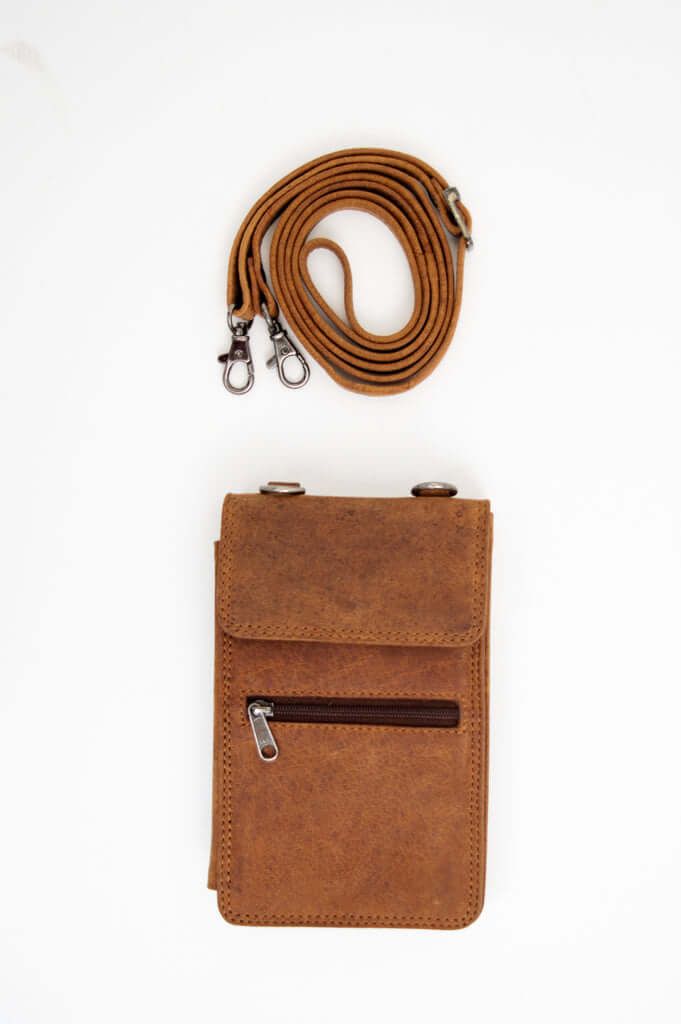 Flat lay of brown leather wallet and detachable strap