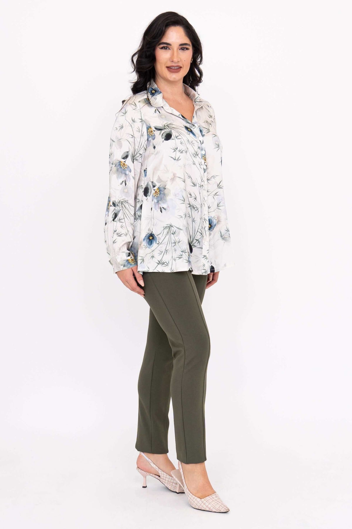 Side angle of woman showcasing Charlotte Blouse with floral design and green pants