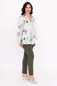 Side angle of woman showcasing Charlotte Blouse with floral design and green pants