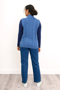Back view of a blue cable knit vest, highlighting the vertical sweater texture and straight, ribbed hemline.