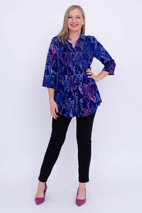 Model standing with hand on hip in Cindy smocked blue floral blouse and black pants