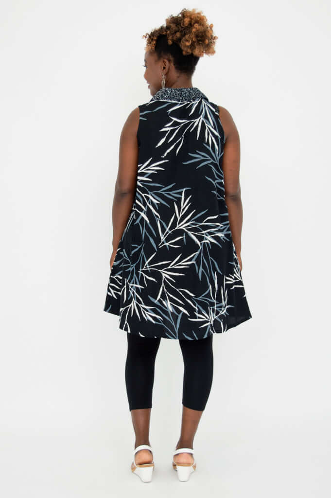 Back view of sleeveless A-line black tunic with white and blue leaf pattern