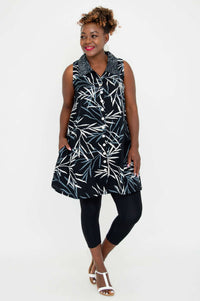 Model posing sideways in A-line black tank top with leaf print and white buttons