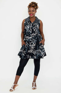 Model in black sleeveless tunic, hands in pockets, with abstract leaf pattern