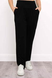 Front view of Clair black bamboo tapered pants with hands in pockets