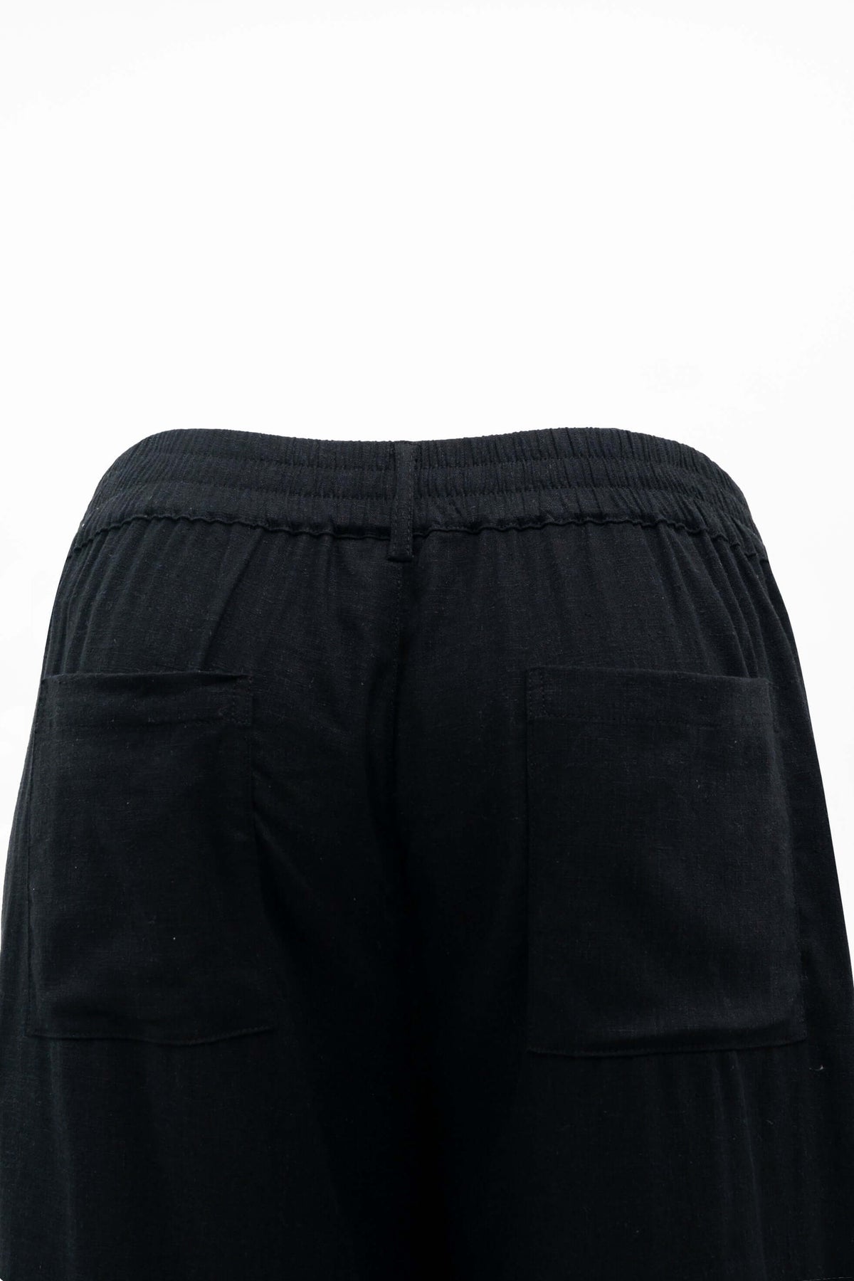 Close-up of black pants featuring elastic waistband and pockets
