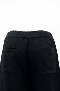 Close-up of black pants featuring elastic waistband and pockets